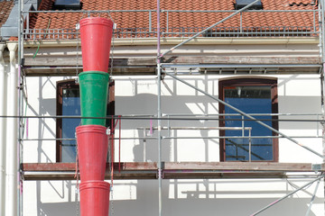 Baugerüst an einem altbau mit bunten Plastikeimern