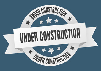 under construction ribbon. under construction round white sign. under construction
