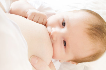 Young woman breastfeeding her little baby boy closeup