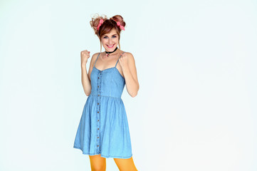 Portrait of a cute happy funny blonde girl with colored hair in a funny dress on a white...