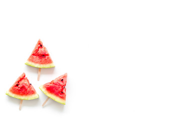 Fresh watermelon on stick for fruit ice cream on white background top view copyspace