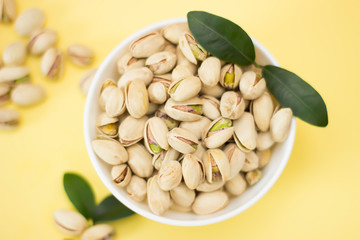 Nuts, pistachios from above on yellow background
