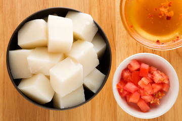 Tofu Jelly in bowl on wooden background,Diced tomatoes in a cup,Top view