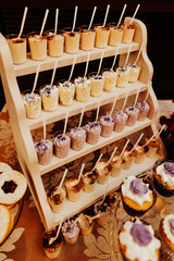 Candy bar wedding cake decorated by flowers standing of festive table