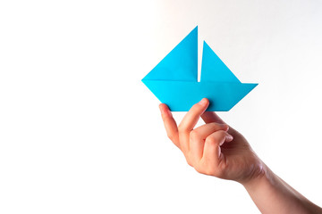 Paper ship in the hand. Blue boat. The concept is medium business. The concept is stability in business. Metaphor - free swimming. Company management. Point in the right direction. Correct Direction