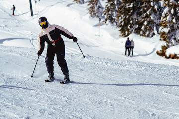 Skiing downhill during sunny day high mountain