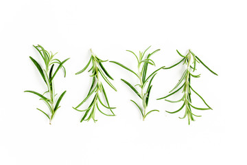 Obraz premium Green branchs and leaves of rosemary isolated on a white background. Мedicinal herbs. Flat lay. Top view
