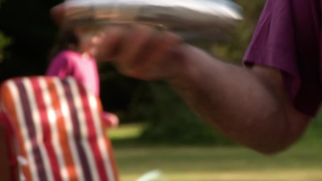 Handheld, medium close up shot of a person shaking a cocktail shaker and pouring the liquid into a glass.