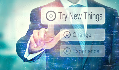 A businessman selecting a Try New Things button on a futuristic display with a concept written on it.