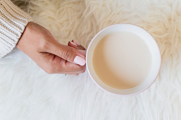Portrait of a beautiful young woman holding a cup of hot coffee