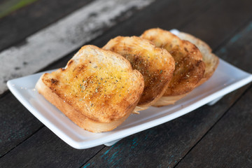 garlic bread. Tasty bread with garlic, cheese and herbs on kitchen table