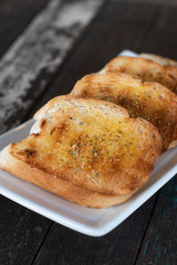 garlic bread. Tasty bread with garlic, cheese and herbs on kitchen table
