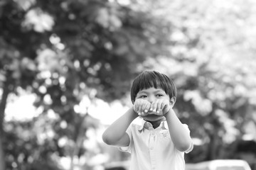 An Asian young boy playing happily and cheerfully outdoor with copy space, black and white tone.