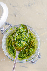 Glass jar with pesto sauce, top view