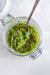 Glass jar with pesto sauce, top view