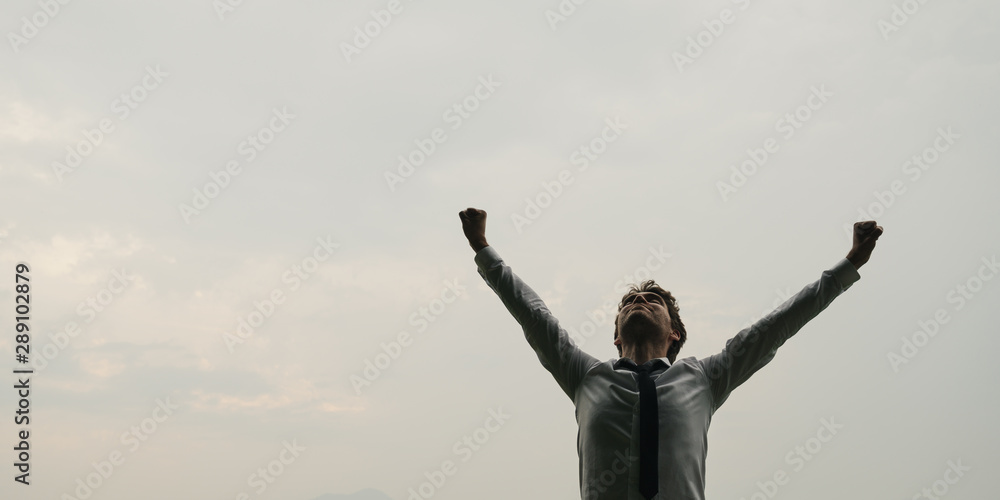 Wall mural businessman standing under sky with his arms raised - Wall murals