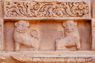Two lions on relief of ansient Indian temple. Artwork on facade of sstone structure of South...