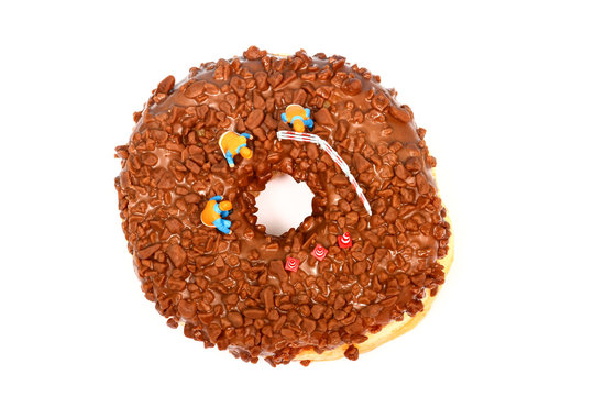 Conceptual image of a miniature figure workmen stood on a chocolate doughnut looking down the centre hole