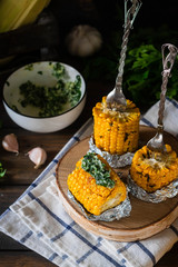 Baked corn with spiced butter on a rustic wooden background. Barbecue food. Thanksgiving Day. Autumn harvest.