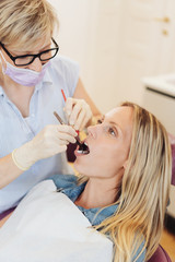 Dental nurse placing a swab or spacer in position