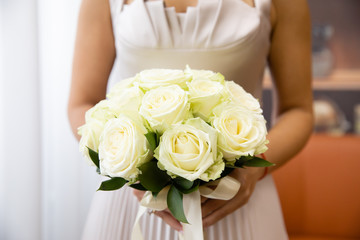 Beautiful wedding bouquet of flowers in the hands of the bride