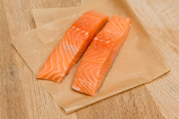 Two Salmon Slices on a Wooden Surface