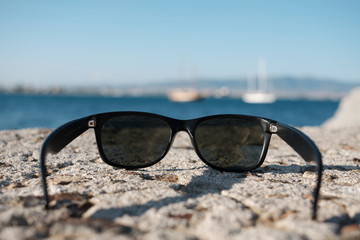 Fototapeta na wymiar close-up of sunglasses with seascape in the background in a sunny day - first person view