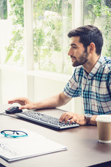 Good looking young business man working on the internet at home