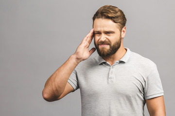 People, crisis, emotions and stress concept - unhappy man suffering from head ache at home. Isolated over grey background.