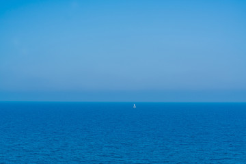 lonesome sail ship somewhere in the blue ocean