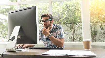 Good looking young business man working on the internet at home