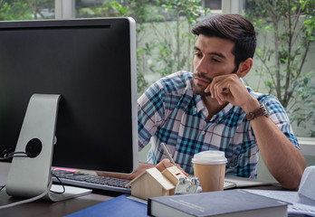 Young caucasion busineesman thinking about his online work.