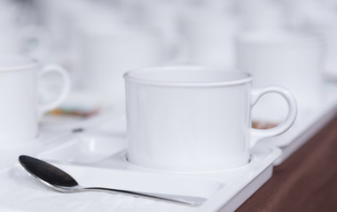 Close up white coffee cup on brown tablecloth for coffee break at conference meeting.Selective focus.