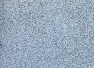 Old wall with decorative blue textured stucco with damage and cracks. Trendy modern abstract background.