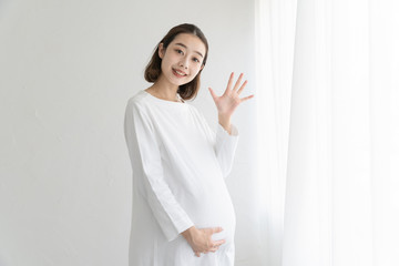 「こんにちは」と手を振る妊婦