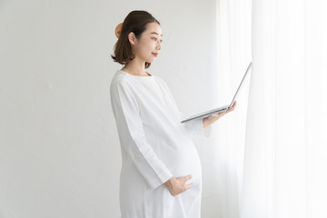 パソコンの画面を見る妊婦