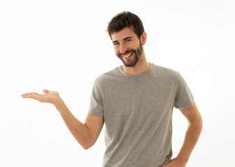 Fototapeta premium Charming smiling young man pointing finger at empty copy space for advertisement