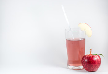 glass of juice and apple on white background