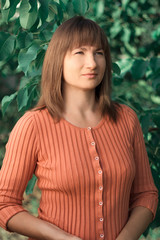 Portrait woman in orange sweater in the park