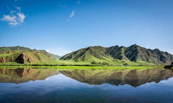 China landscape. Sangke grassland close to Xiahe, Gansu, China. Beautiful mountain reflections at the wetlands of Gannan. 