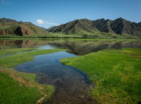 China landscape. Sangke grassland close to Xiahe, Gansu, China. Beautiful mountain reflections at the wetlands of Gannan. 