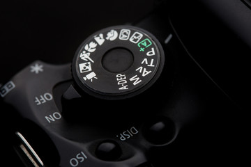 closeup of the Camera Modes wheel dial on a camera shot on a black background