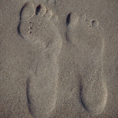 Fototapeta na wymiar Footprint of a woman and a man on the beach. Concept: holiday or calendar and picture postcards