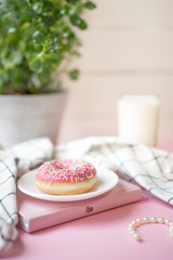 donut on a white plate and a pink background
