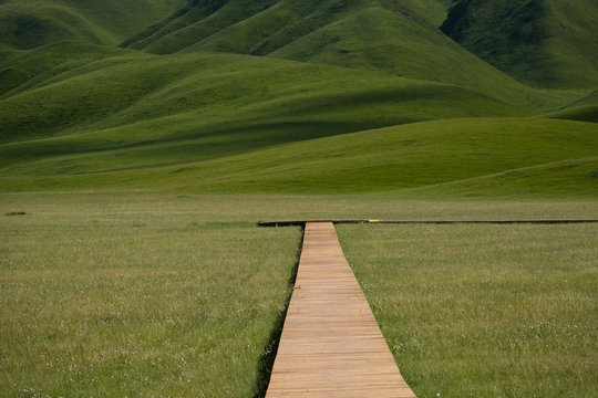 wooden pathway through the Ganjia grasslands of Gannan autonomous prefecture near Xiahe, Gansu, China. Endless grassfields. 