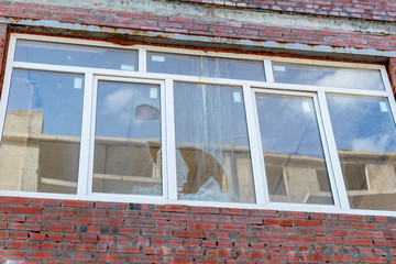 Broken window on an abandoned construction site after developer bankruptcy