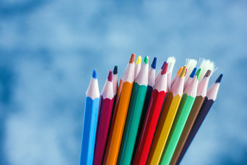 Fototapeta premium Bunch of colorful art supplies Closeup set of bright multicolored pencils and brushes placed against blue background