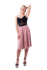 Sexy fashion blond hair woman looking down and posing with hand in hair. Full body isolated on white background.