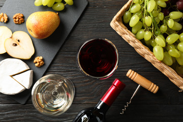 Grape, cheese, walnut, glasses with wine, on wooden background, top view