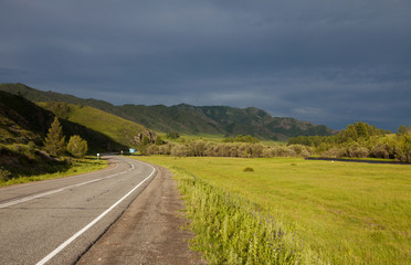 Mountain road in the rays of the setting sun